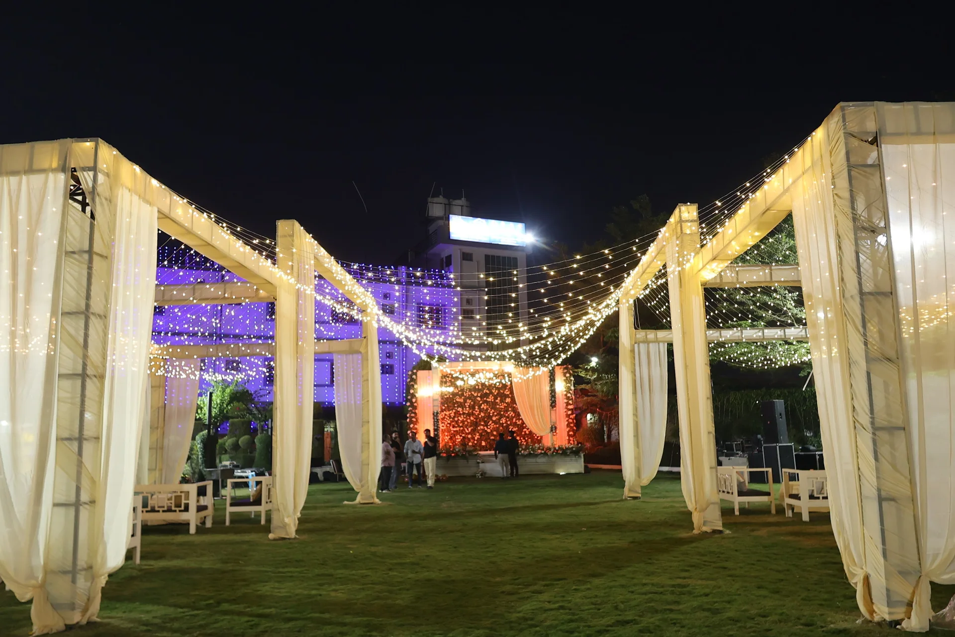 Actual ivory-draped pavilions and floral celebration backdrop at Bhandari Farms