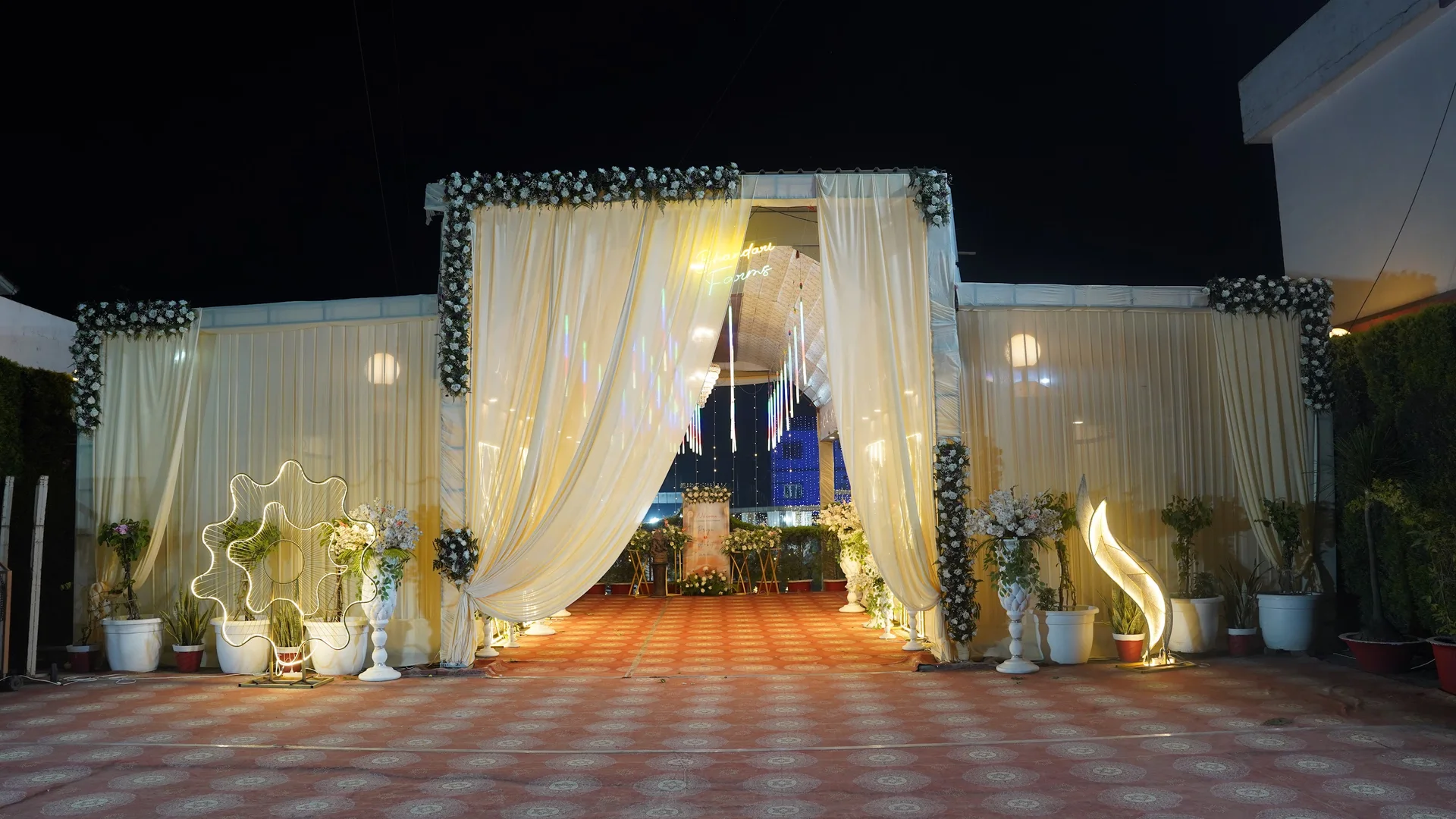 The actual Bhandari Farms floral entrance with ivory drapes